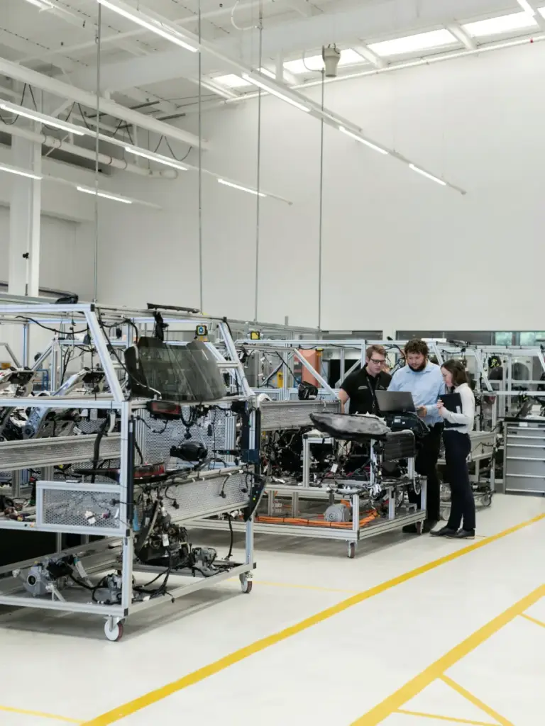Ingenieurinnen und Ingenieure an einer Fertigungsanlage